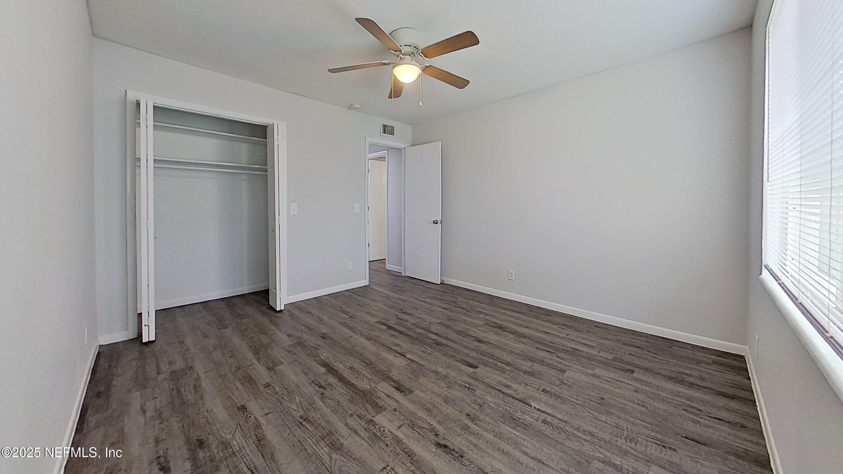 2216 Spring Park Road, Unit 8 Jacksonville, FL 32207 - Photo 29 of 32 an empty room with wooden floor ceiling fan and windows