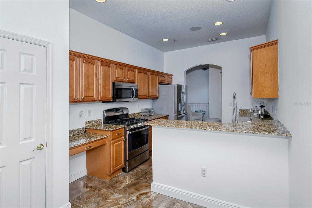 8363 Miramar Way, Unit 203 Lakewood Ranch, FL 34202 - Photo 15 of 73 a kitchen with stainless steel appliances granite countertop a sink stove and microwave