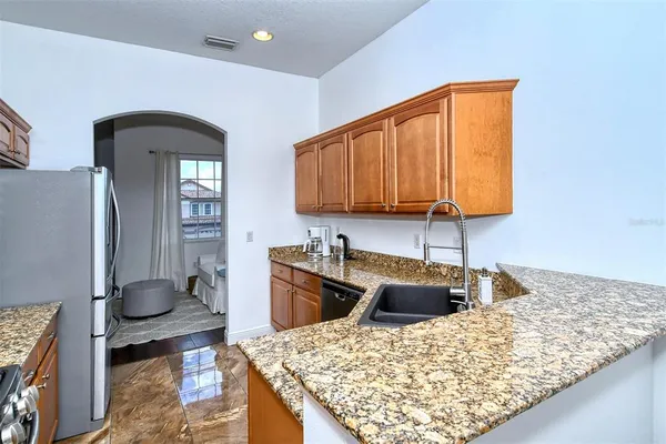 a living room with furniture a flat screen tv and a refrigerator