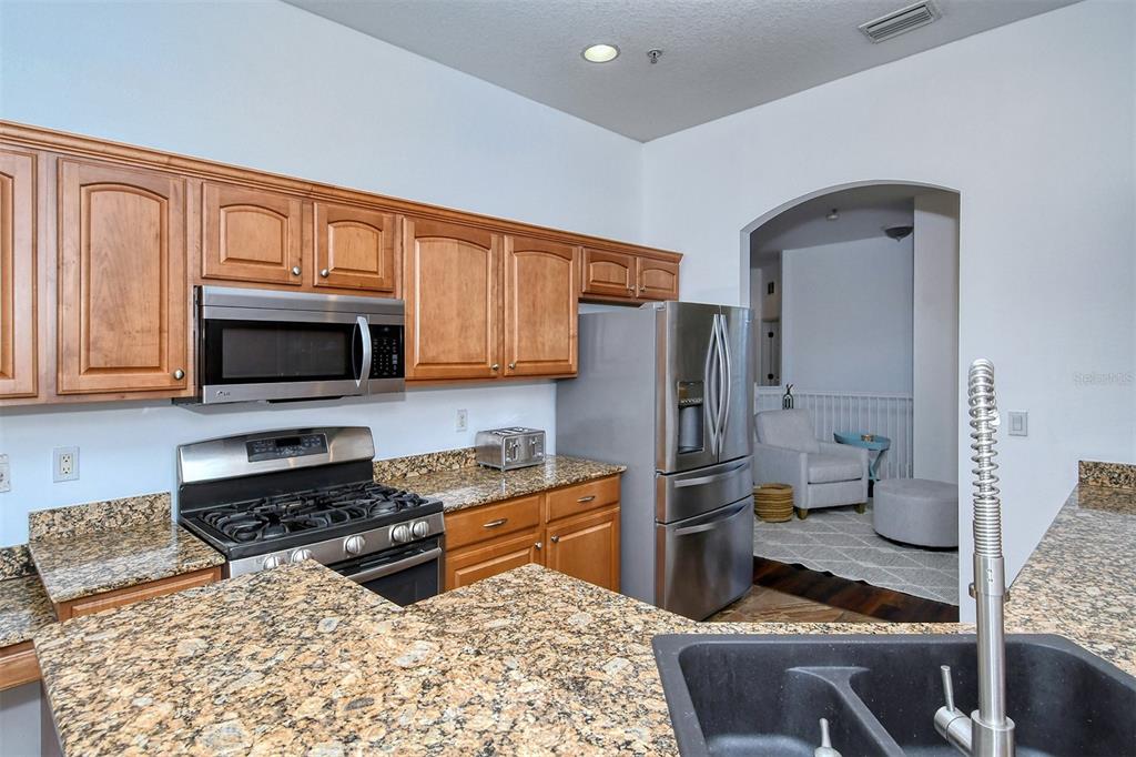 8363 Miramar Way, Unit 203 Lakewood Ranch, FL 34202 - Photo 17 of 73 a kitchen with stainless steel appliances granite countertop a stove refrigerator and microwave