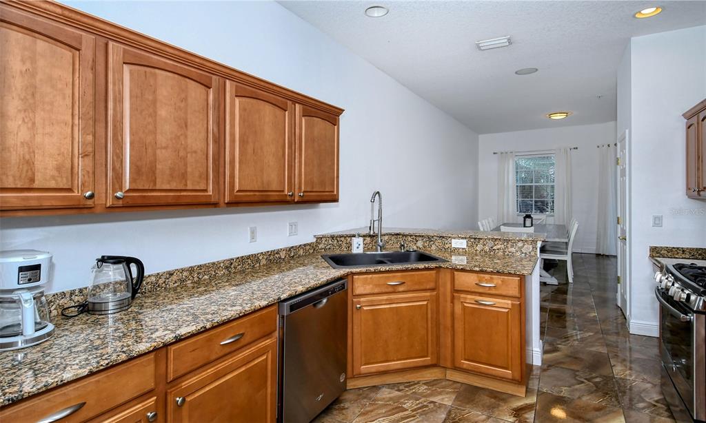 8363 Miramar Way, Unit 203 Lakewood Ranch, FL 34202 - Photo 18 of 73 a kitchen with granite countertop a sink stove and cabinets