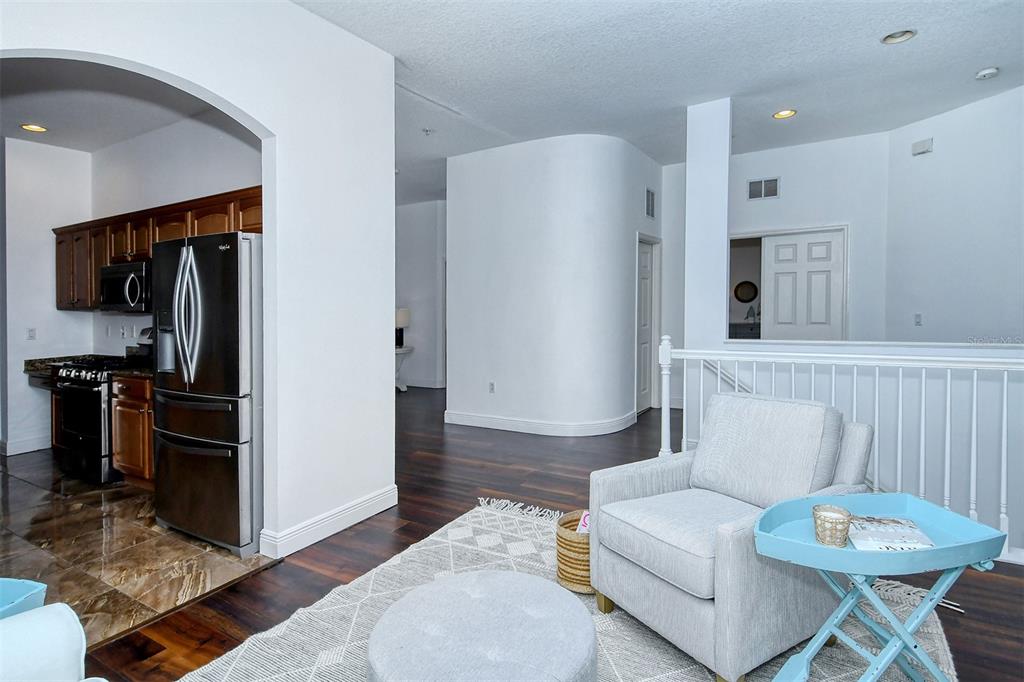 8363 Miramar Way, Unit 203 Lakewood Ranch, FL 34202 - Photo 21 of 73 a living room with furniture a flat screen tv and a refrigerator