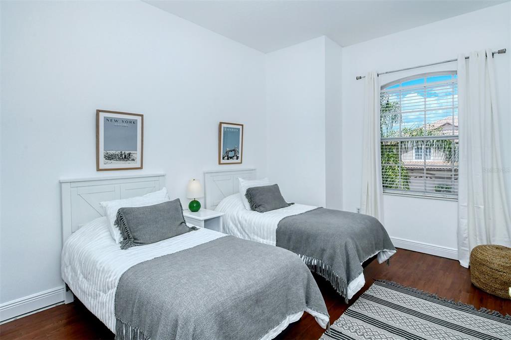 8363 Miramar Way, Unit 203 Lakewood Ranch, FL 34202 - Photo 33 of 73 a bedroom with two beds and wooden floor