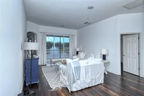 a living room with furniture a flat screen tv and a large window