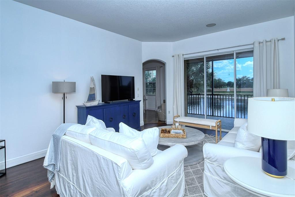 8363 Miramar Way, Unit 203 Lakewood Ranch, FL 34202 - Photo 5 of 73 a living room with furniture a flat screen tv and a large window
