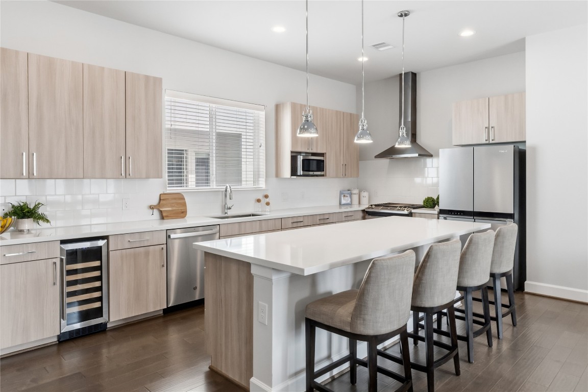 1509 Elgin Street Houston, TX 77004 - Photo 9 of 34 Experience cooking in a modern kitchen featuring a gas cooktop and a sleek beverage fridge. *staged photo