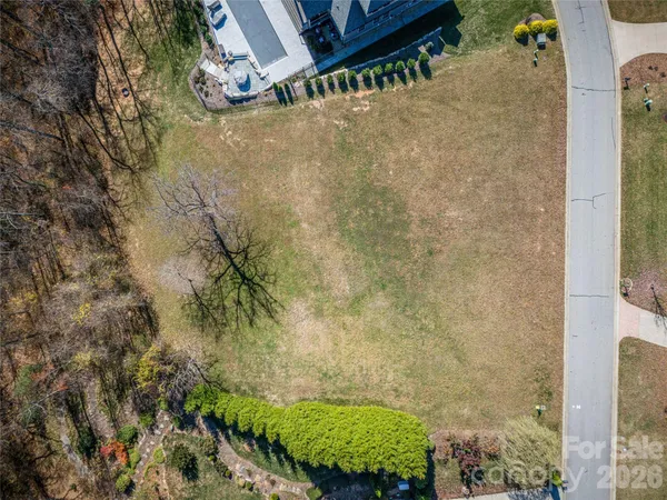 a aerial view of a house next to a yard and mountain
