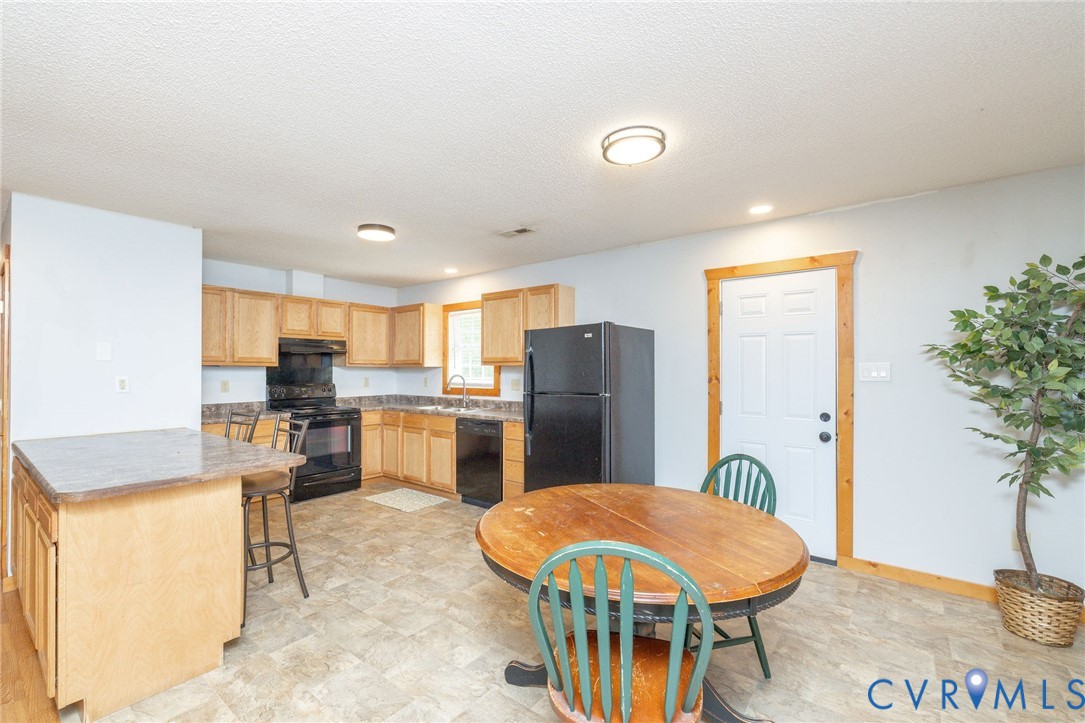 460 Horseshoe Road Jarratt, VA 23867 - Photo 7 of 24 a kitchen with refrigerator and chairs