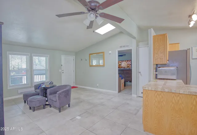 a living room with furniture and a open kitchen view