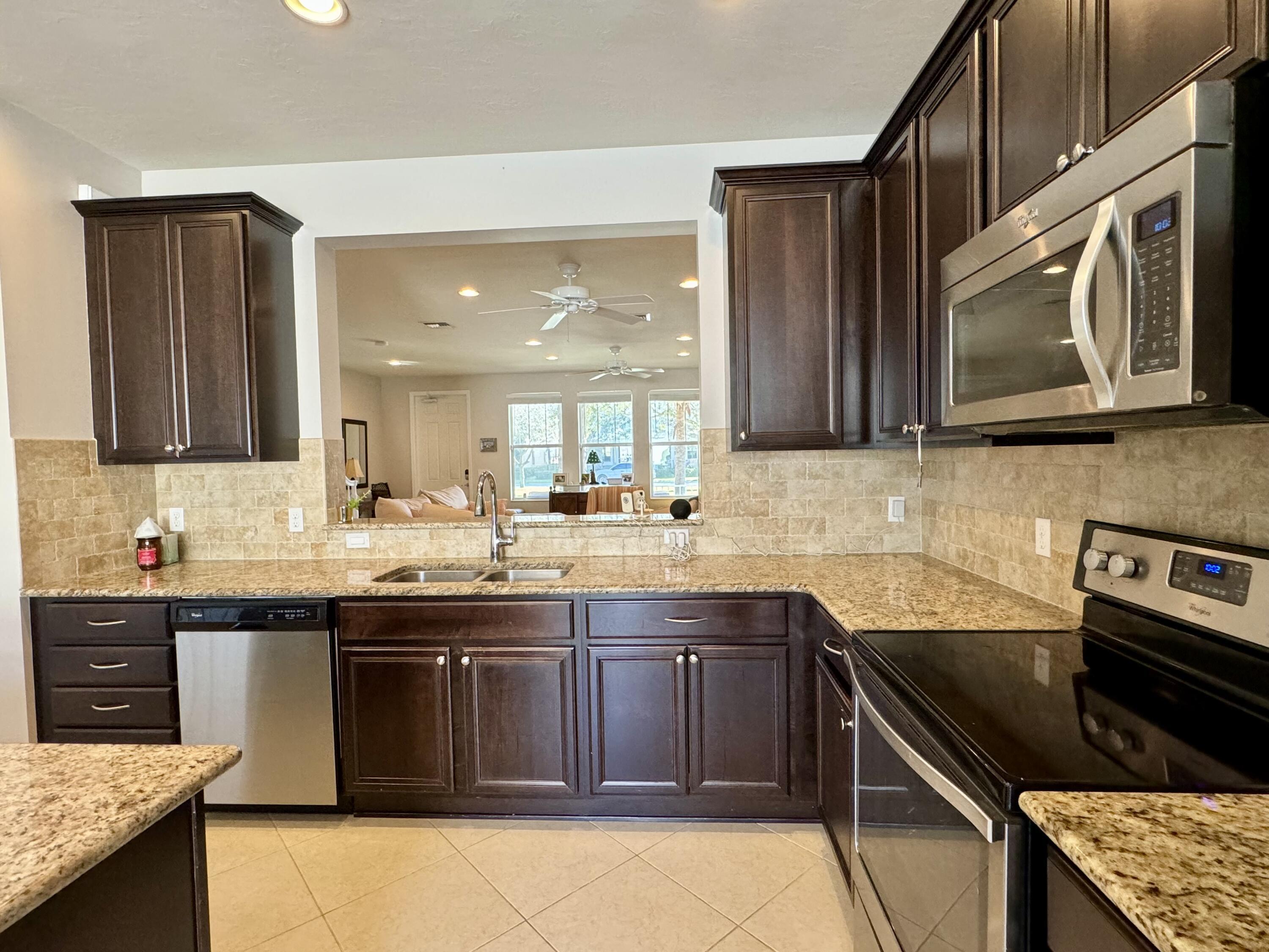 2758 Avalon Way Jupiter, FL 33458 - Photo 15 of 51 a kitchen with stainless steel appliances granite countertop a stove sink and cabinets