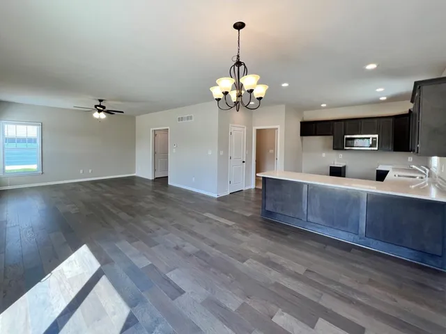 a view of a kitchen with sink microwave and wooden floor