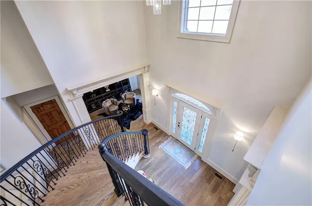 a view of a livingroom with furniture stairs wooden floor and windows