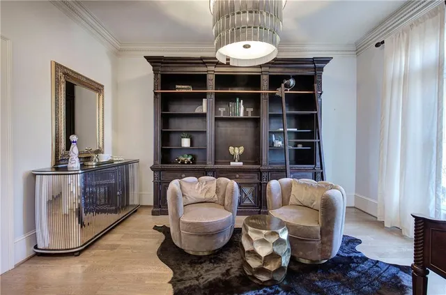 a dining room with furniture a chandelier and wooden floor