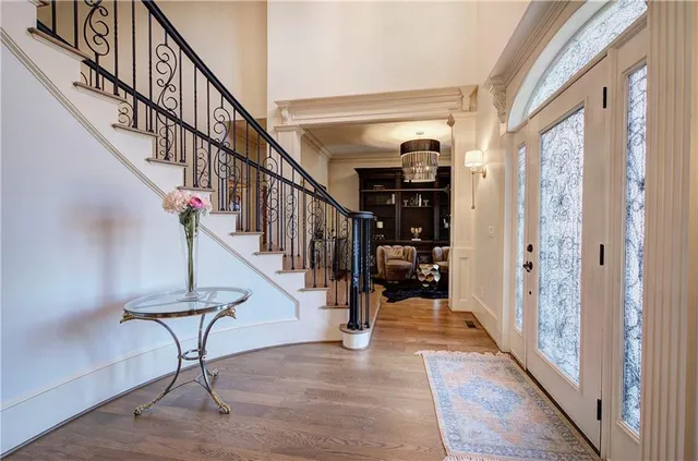 a view of a hallway with wooden floor and staircase