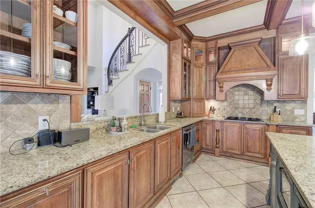 a kitchen with stainless steel appliances granite countertop a sink a stove and cabinets