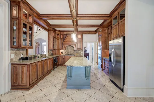 a large white kitchen with a large window and refrigerator