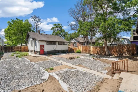 a front view of a house with a yard tree and wooden fence