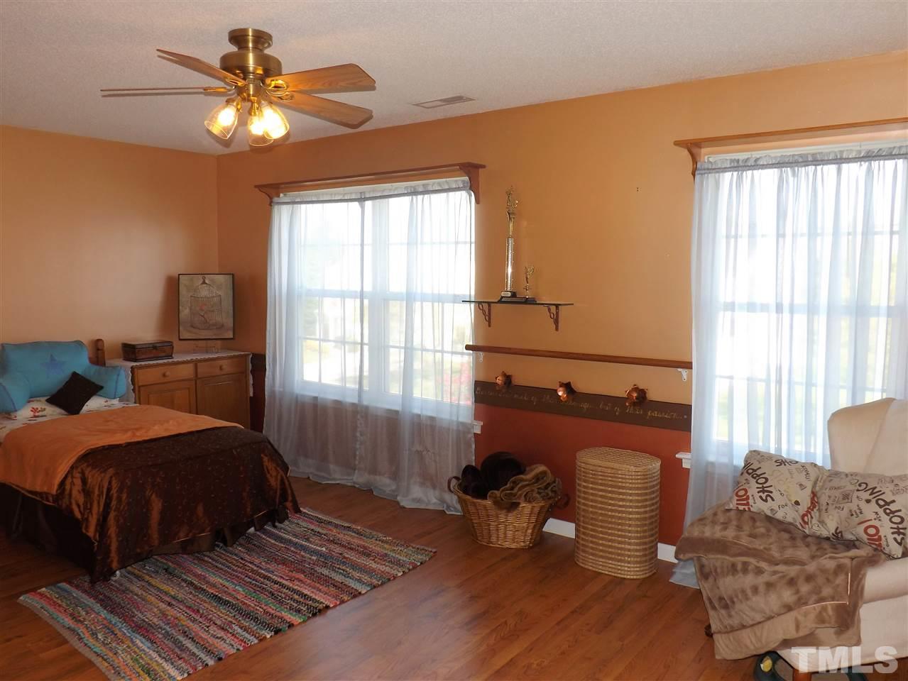 4904 Marathon Lane Raleigh, NC 27616 - Photo 14 of 25 a bedroom with a bed and wooden floor