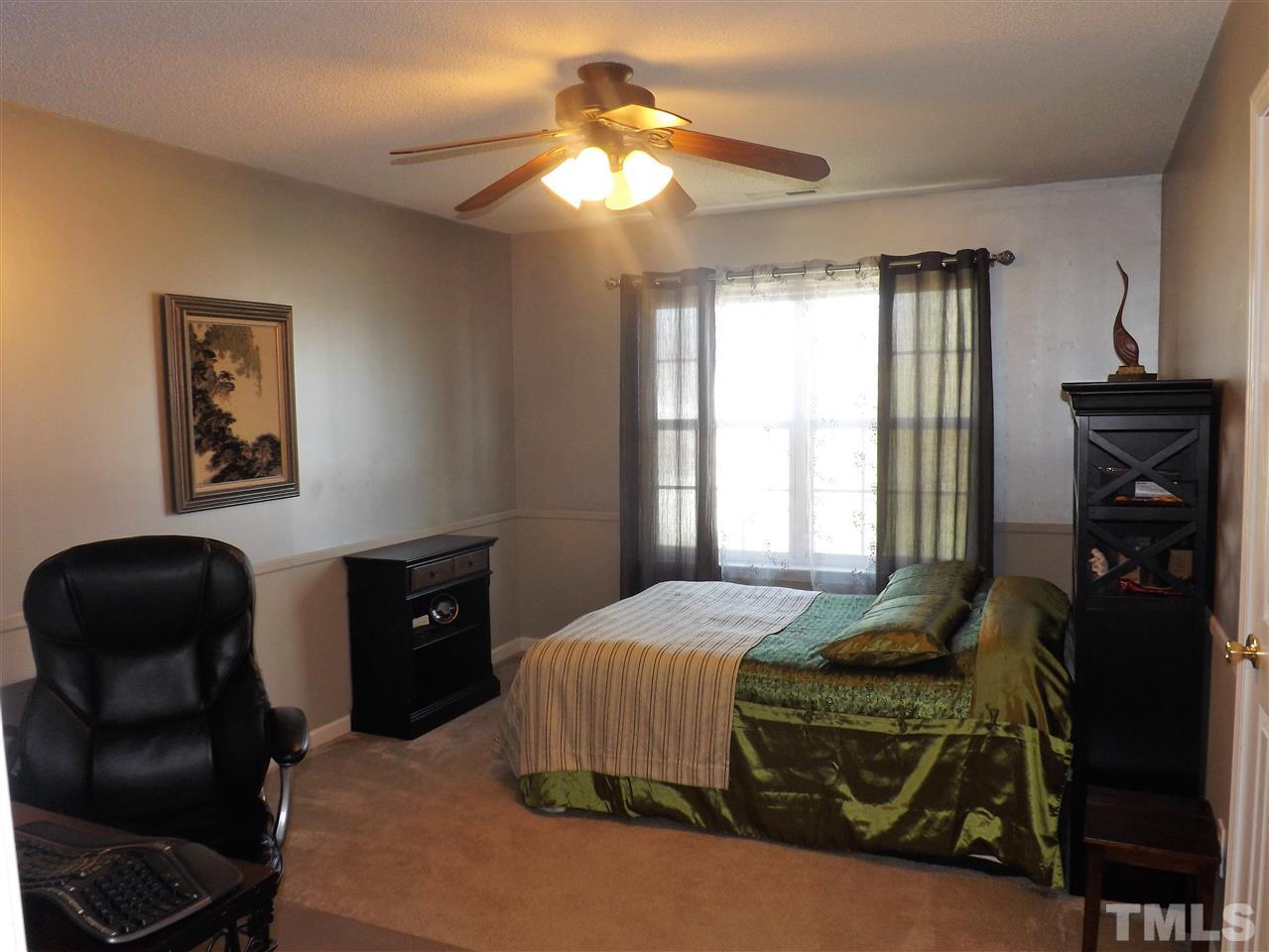 4904 Marathon Lane Raleigh, NC 27616 - Photo 16 of 25 a bedroom with a bed and a chandelier
