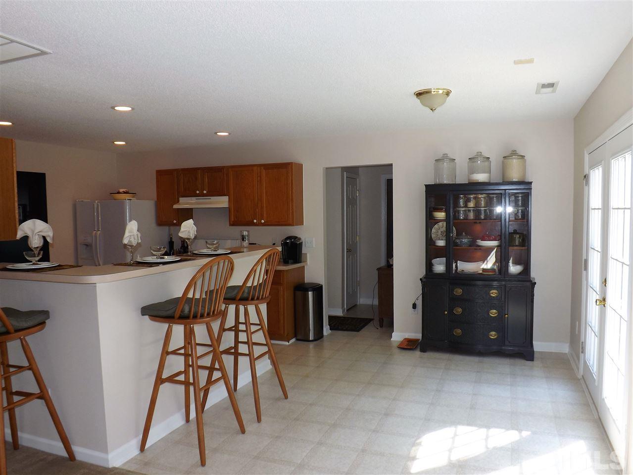 4904 Marathon Lane Raleigh, NC 27616 - Photo 9 of 25 a kitchen with stainless steel appliances granite countertop a refrigerator a stove a sink a dining table and chairs with wooden floor