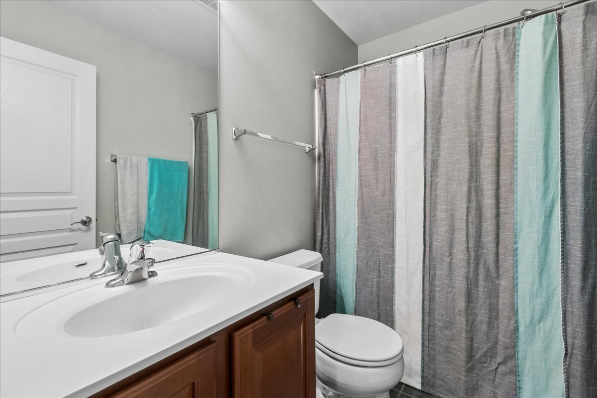 2459 Anna Way Elgin, IL 60124 - Photo 16 of 20 a bathroom with a sink a toilet and shower curtain