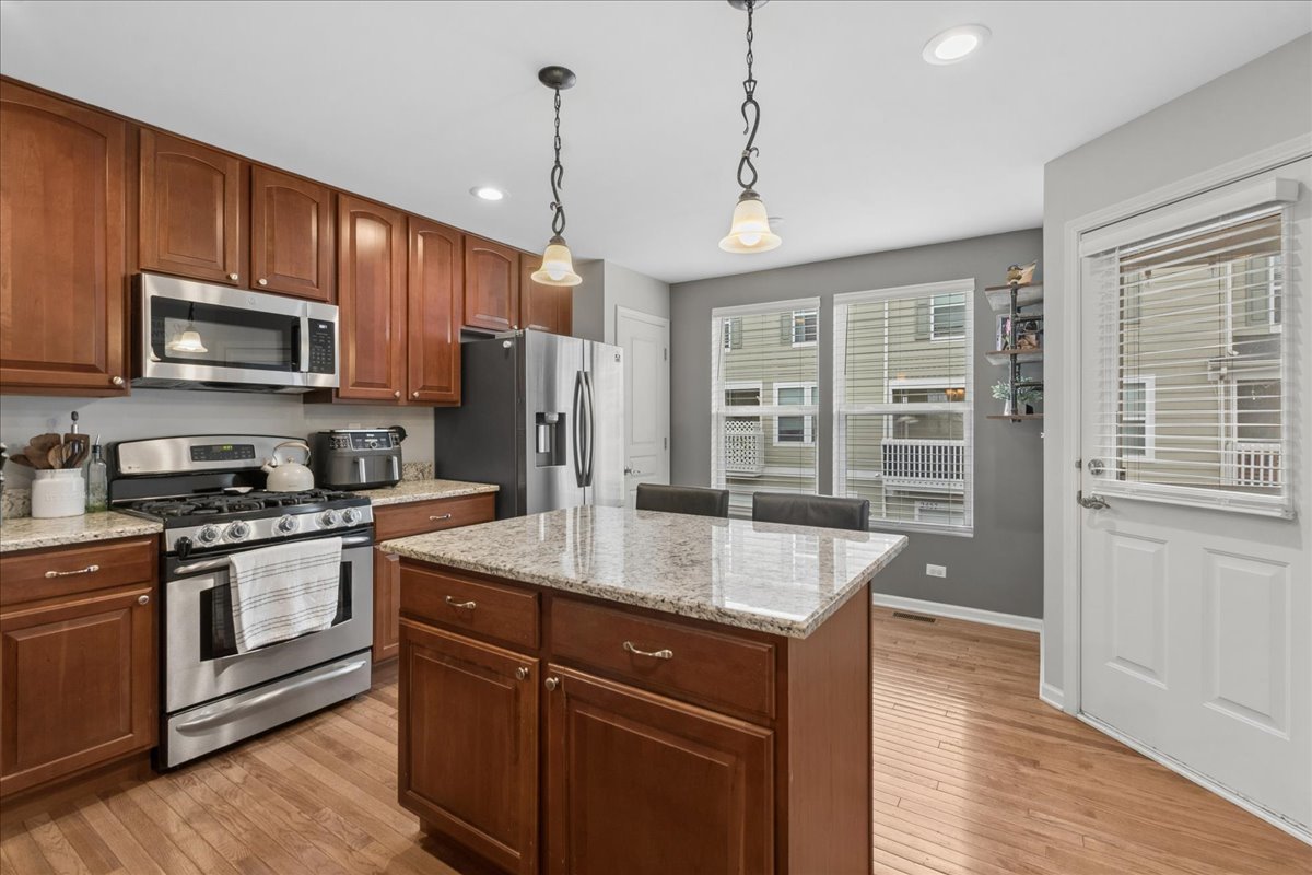 2459 Anna Way Elgin, IL 60124 - Photo 9 of 20 a kitchen with stainless steel appliances granite countertop a sink stove and refrigerator