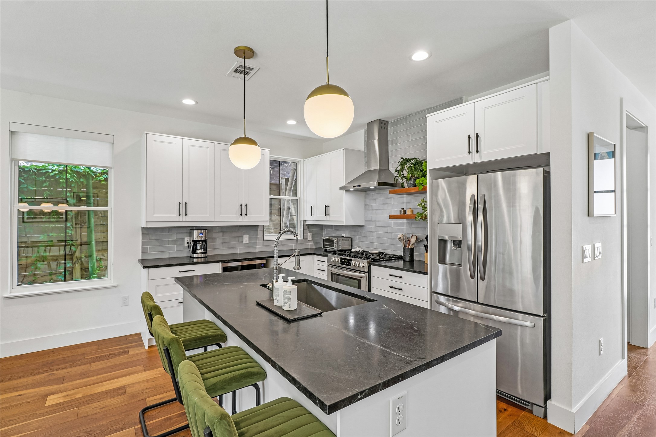 1706 Perez Street, Unit 1 Austin, TX 78721 - Photo 14 of 36 Culinary dreams come alive in this kitchen, featuring an expansive island, sleek stainless appliances, and warm wood flooring.