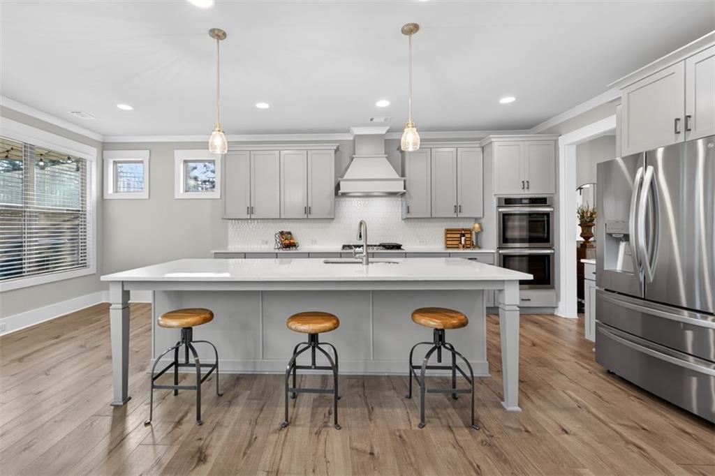 2588 Traditions Way Jefferson, GA 30549 - Photo 19 of 84 a kitchen with stainless steel appliances granite countertop a refrigerator a stove a sink dishwasher a dining table and chairs with wooden floor