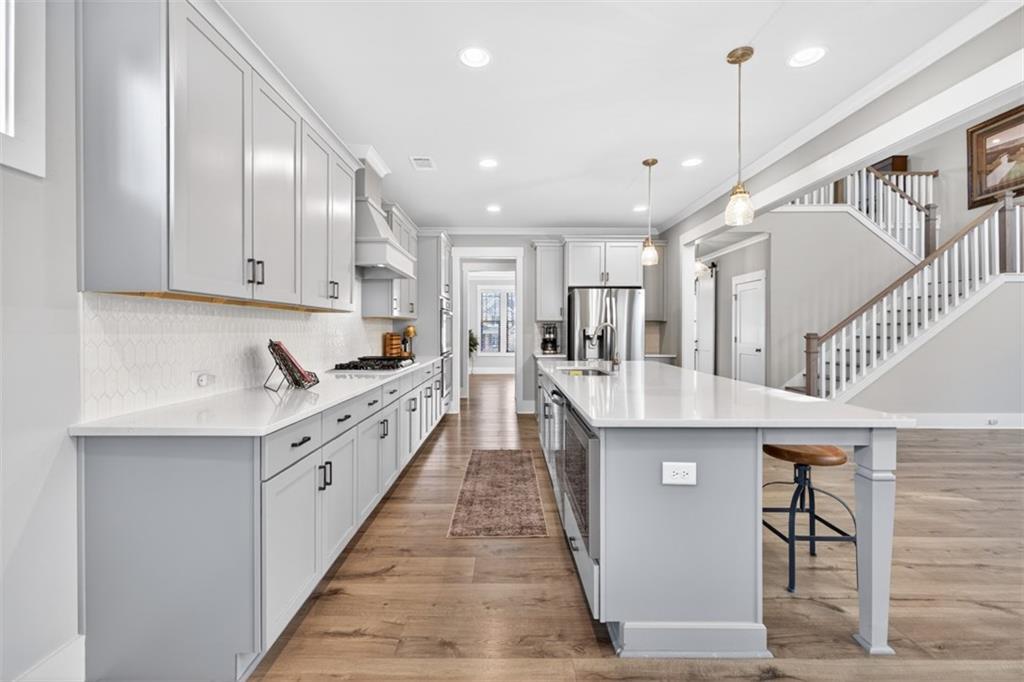 2588 Traditions Way Jefferson, GA 30549 - Photo 21 of 84 a large kitchen with stainless steel appliances kitchen island granite countertop a lot of cabinets and wooden floor