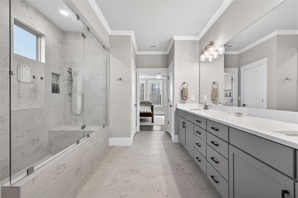 2588 Traditions Way Jefferson, GA 30549 - Photo 35 of 84 a large spacious bathroom with double vanity a double vanity sink a large mirror and a bathtub