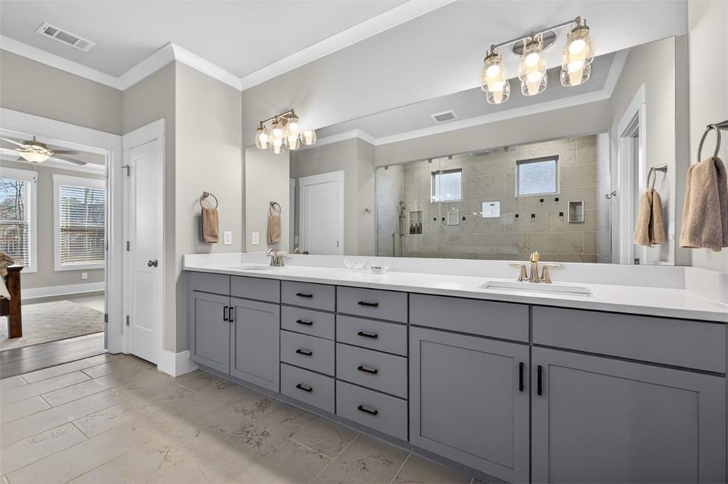 2588 Traditions Way Jefferson, GA 30549 - Photo 36 of 84 a bathroom with double vanity sinks a vanity a lamp and a mirror