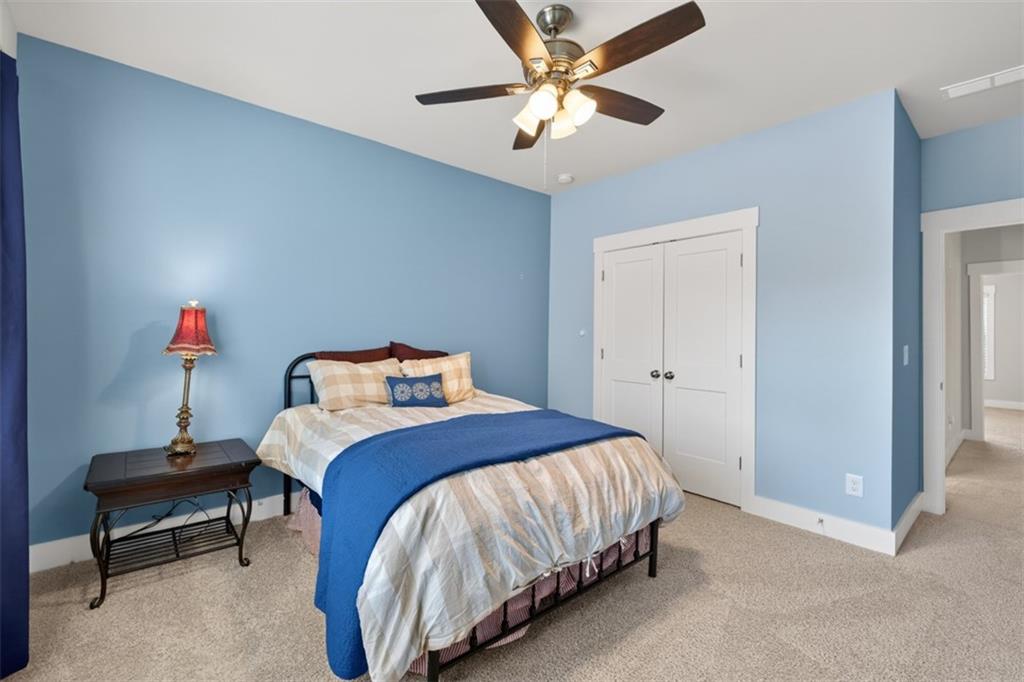 2588 Traditions Way Jefferson, GA 30549 - Photo 44 of 84 a bedroom with a bed and a chandelier