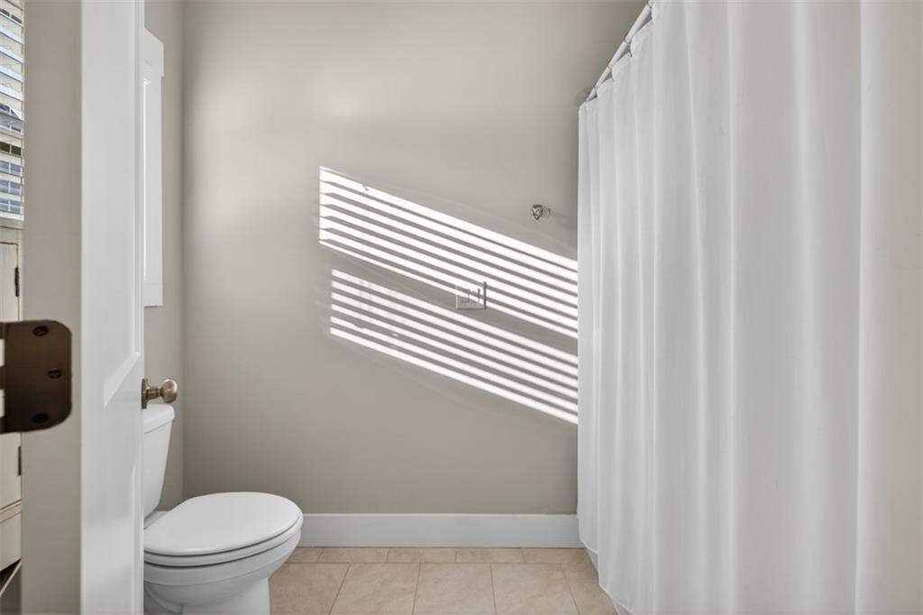 2588 Traditions Way Jefferson, GA 30549 - Photo 50 of 84 a bathroom with a toilet and a shower curtain