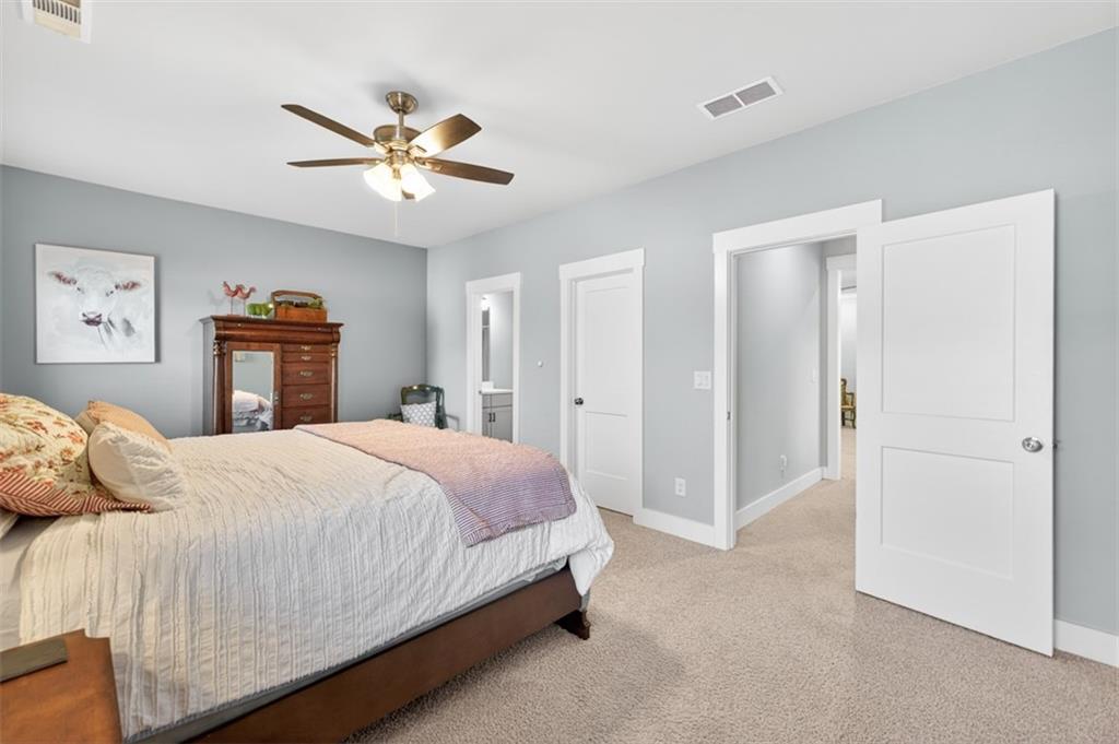 2588 Traditions Way Jefferson, GA 30549 - Photo 54 of 84 a bedroom with a large bed and a chandelier