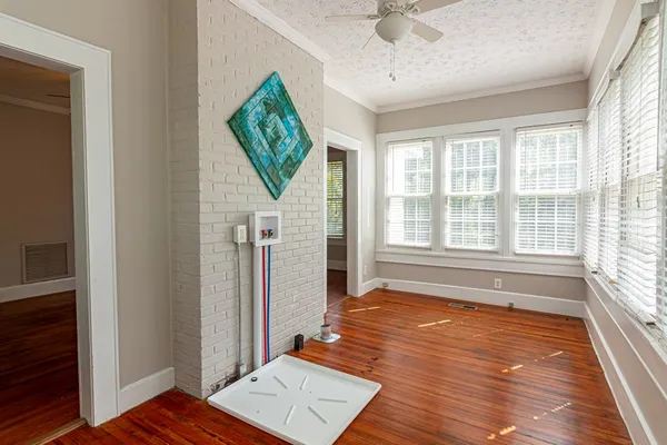 a view of an empty room with a window and wooden floor