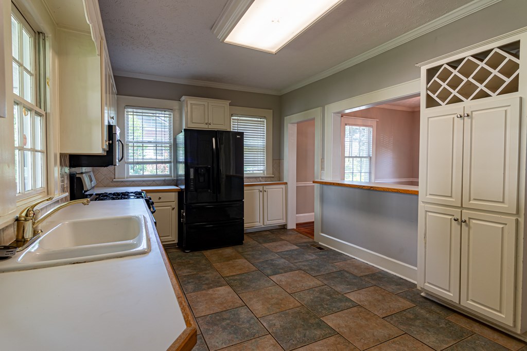 1519 16th Avenue Columbus, GA 31901 - Photo 4 of 16 a kitchen with a refrigerator sink and cabinets