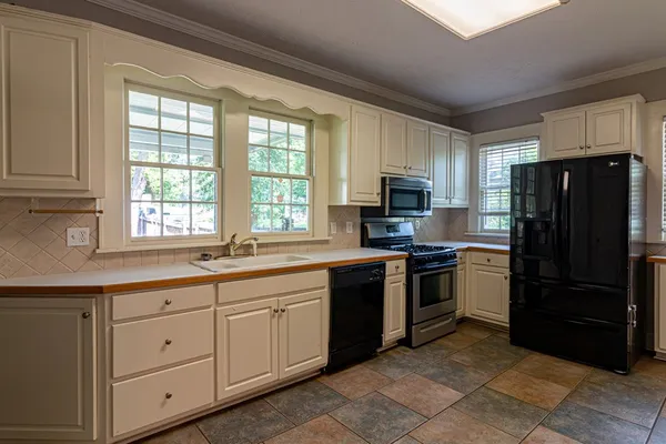 a kitchen with stainless steel appliances granite countertop a refrigerator and a sink