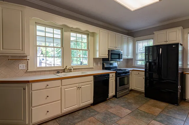 a kitchen with stainless steel appliances granite countertop a refrigerator and a sink