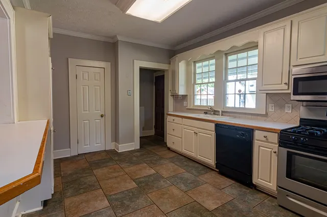 a kitchen with stainless steel appliances granite countertop a stove a sink and a refrigerator