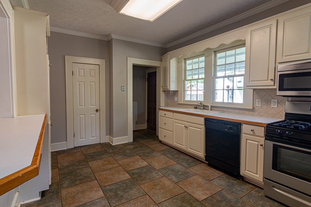 1519 16th Avenue Columbus, GA 31901 - Photo 6 of 16 a kitchen with stainless steel appliances granite countertop a stove a sink and a refrigerator