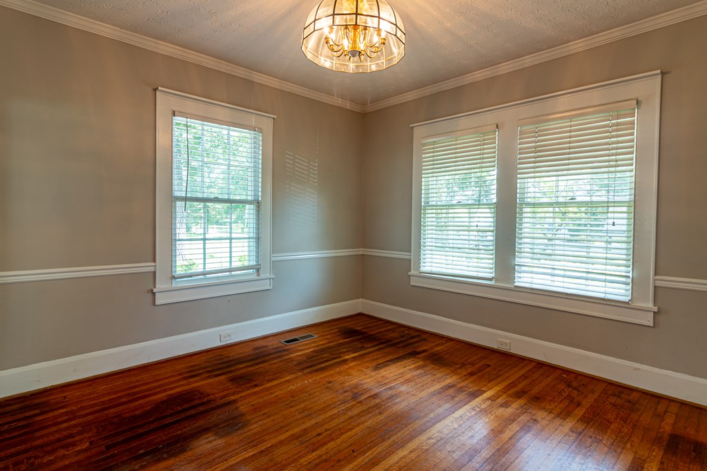 1519 16th Avenue Columbus, GA 31901 - Photo 7 of 16 a view of an empty room with wooden floor and a window