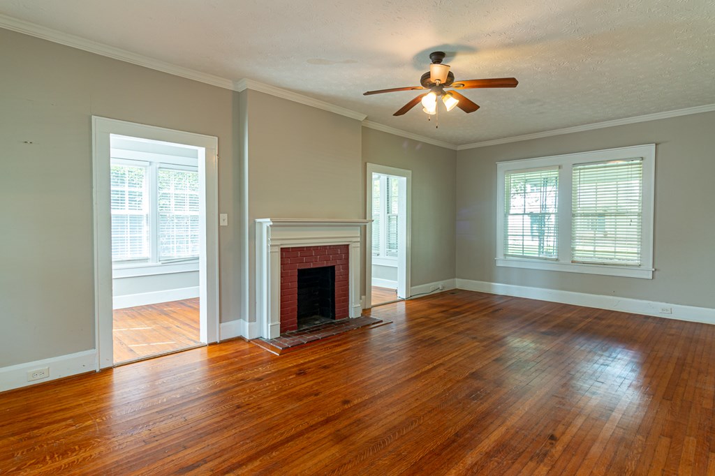 1519 16th Avenue Columbus, GA 31901 - Photo 9 of 16 a view of an empty room with wooden floor fireplace and a window