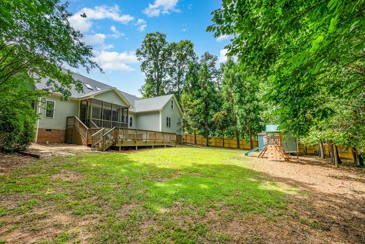 1309 Taylor Farm Road Raleigh, NC 27603 - Photo 3 of 38 Large flat play area in this back yard on a wooded lot. Only a portion of the 2/3 of an acre that is fenced inside property back line. Permanent open space behind per plat map. Exterior Back