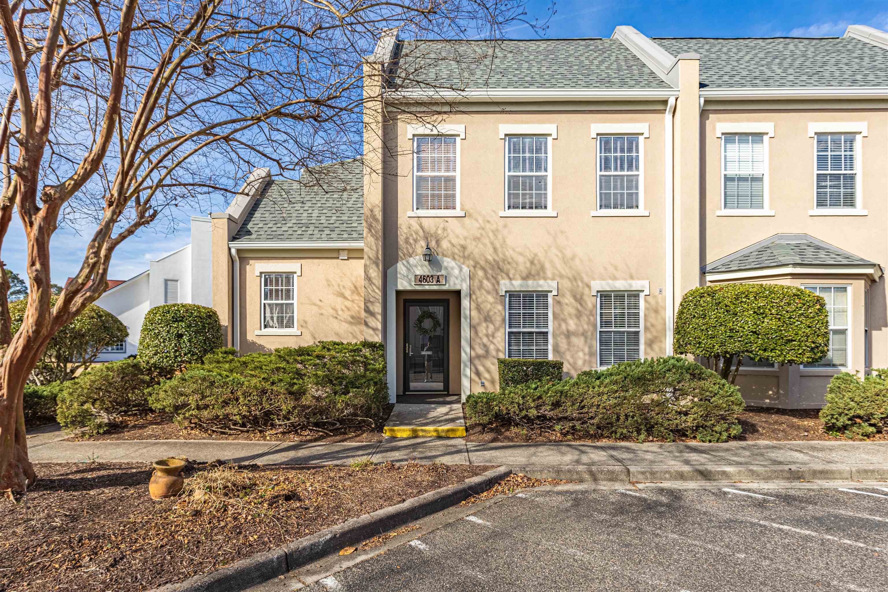 View of front of home featuring roof with shingles and stucco siding