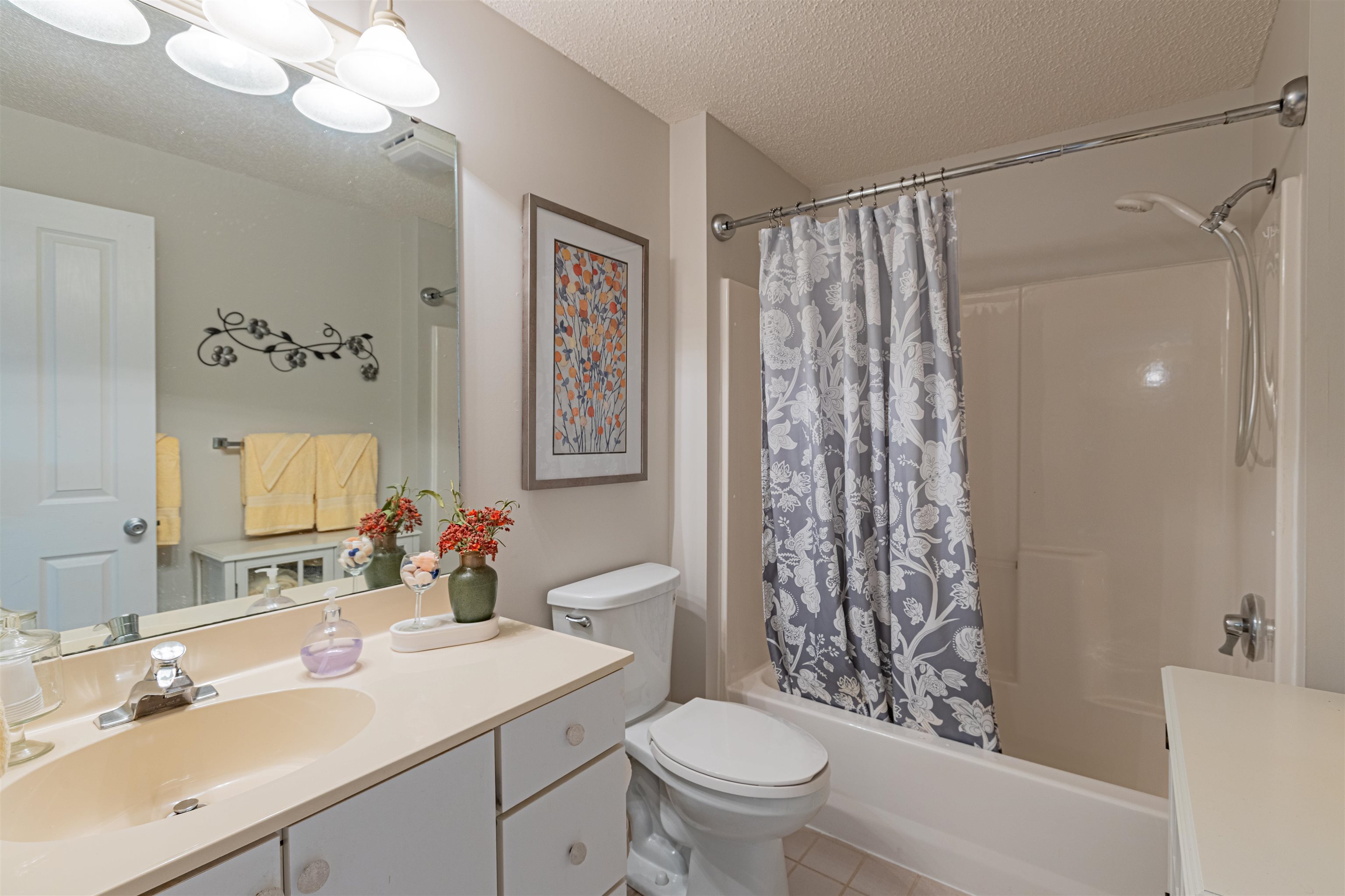 4603 Arran Court, Unit A Myrtle Beach, SC 29579 - Photo 10 of 32 Full bath featuring vanity, a textured ceiling, shower / bathtub combination with curtain, and light tile patterned floors