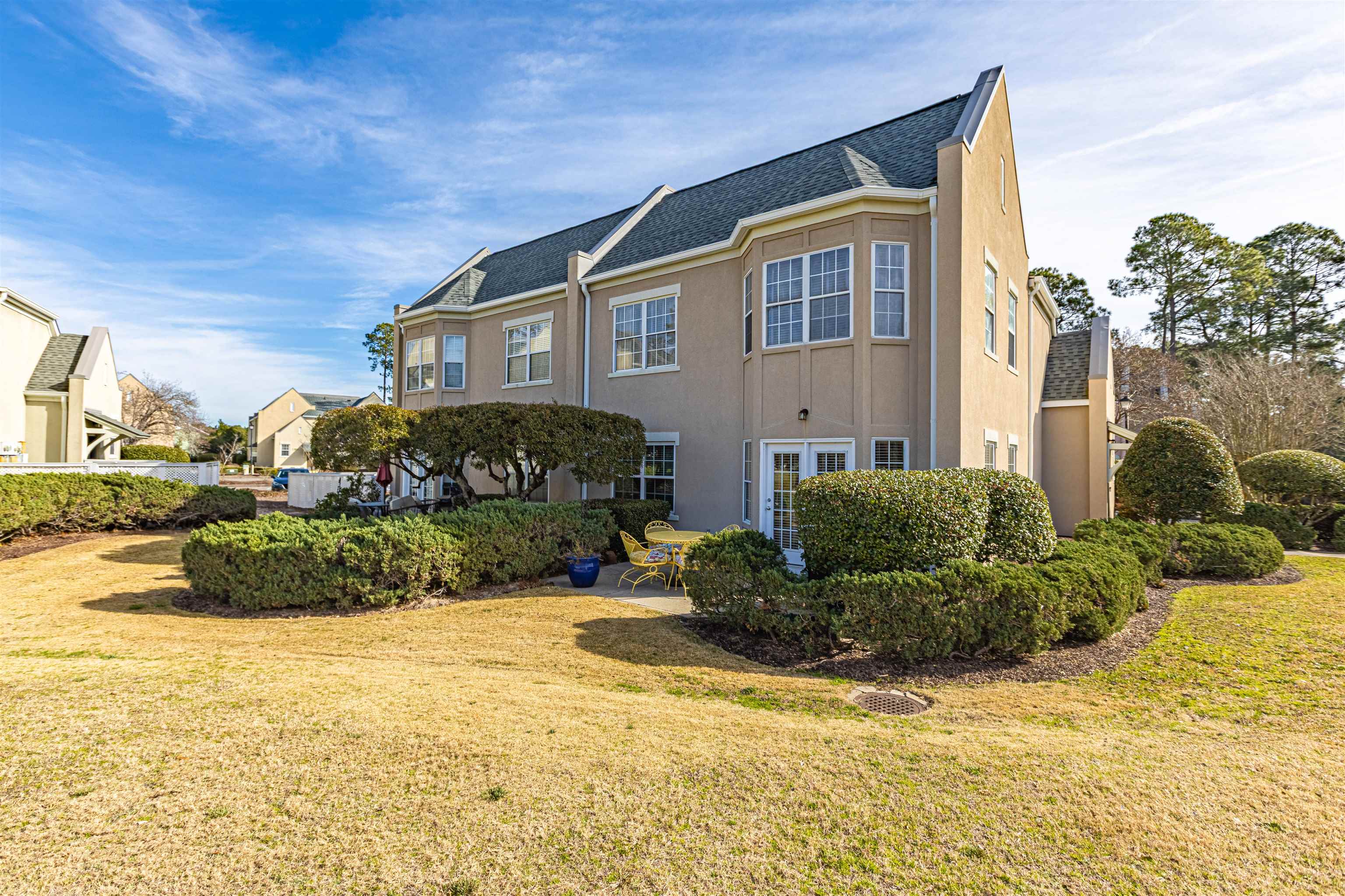4603 Arran Court, Unit A Myrtle Beach, SC 29579 - Photo 25 of 32 View of side of home with stucco siding, a yard, and a shingled roof
