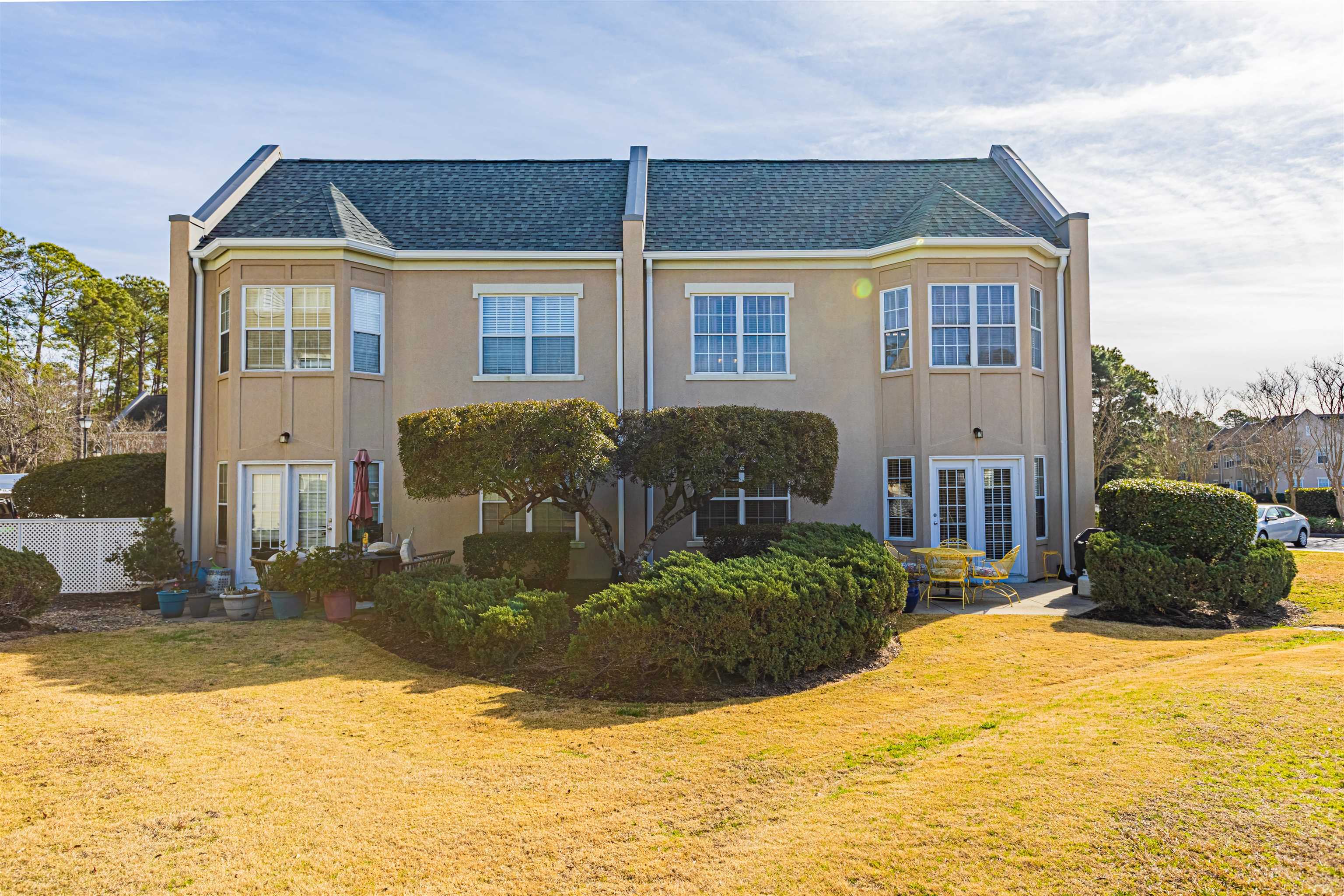 4603 Arran Court, Unit A Myrtle Beach, SC 29579 - Photo 26 of 32 Back of house featuring a shingled roof, a yard, and stucco siding