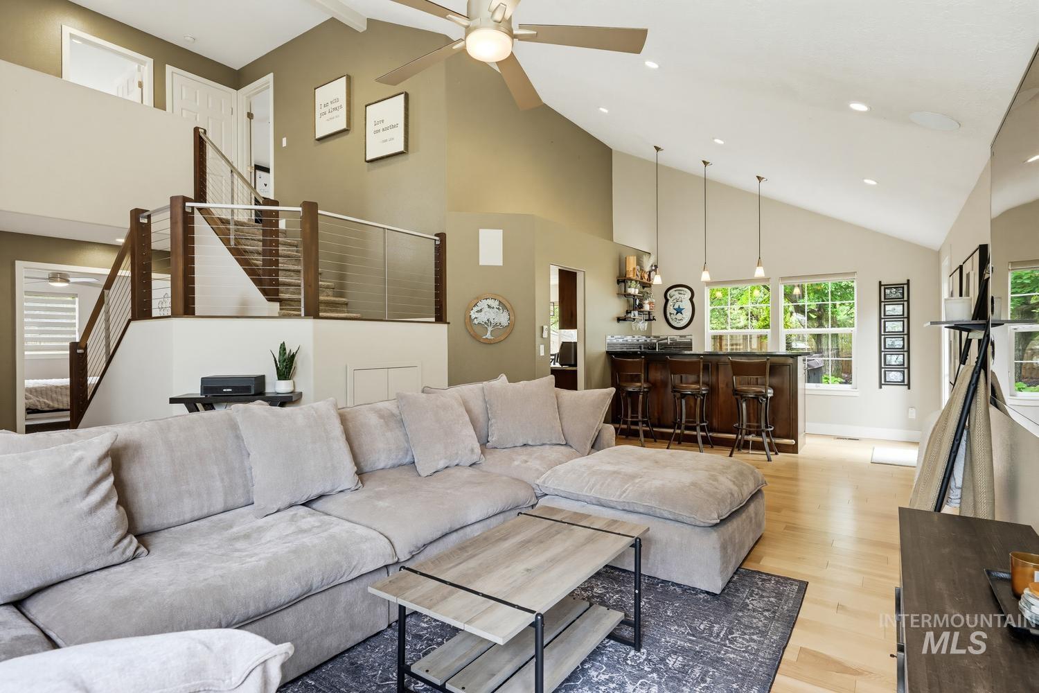 369 South Winthrop Way Boise, ID 83709 - Photo 7 of 50 Spacious living area featuring vaulted ceilings, wood-finish flooring, and a built-in wet bar with pendant lighting