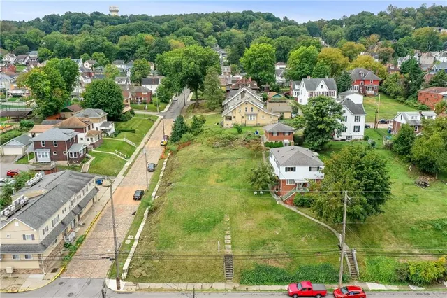 an aerial view of residential houses with outdoor space and street view