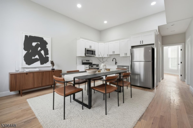 a kitchen with a table chairs refrigerator and microwave